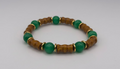 Bracelet with green beads and wooden accents on a light gray background